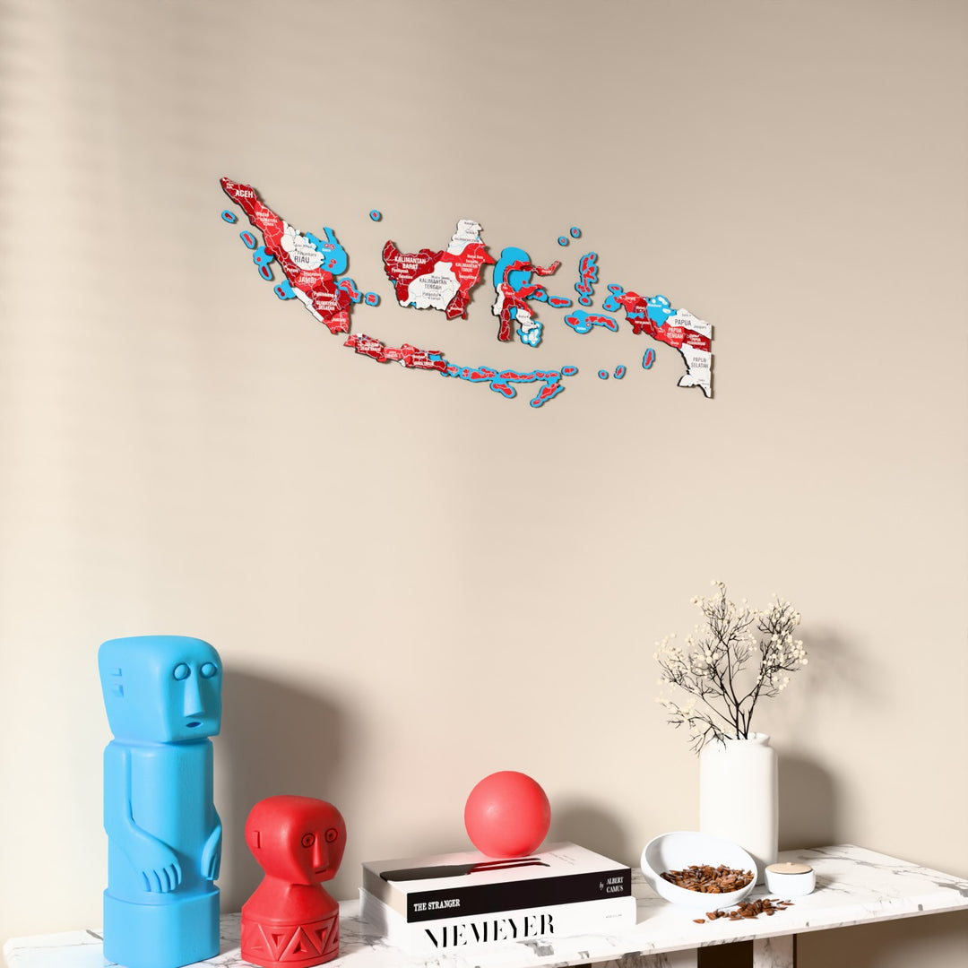 Flag colored Indonesia wooden wall map on a beige wall above a console with figurines