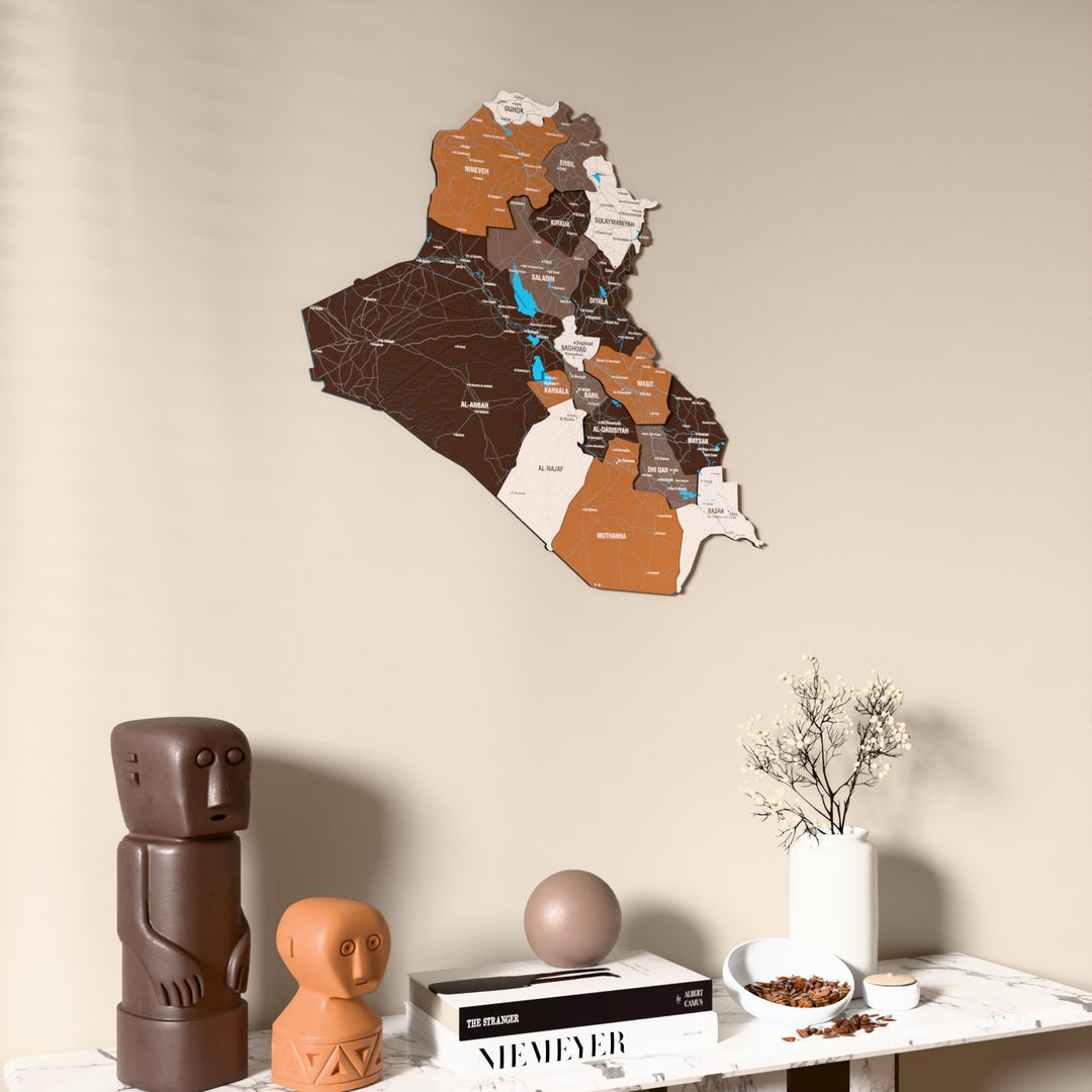 Soil Iraq wooden wall map on a beige wall above a console with figurines