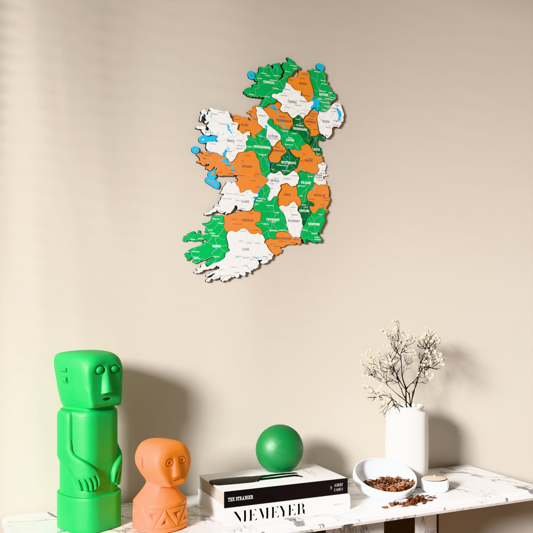 Flag colored Ireland wooden wall map on a beige wall above a console with figurines