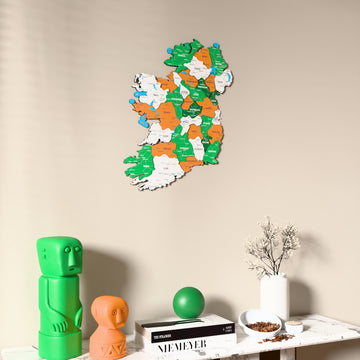 Flag colored Ireland wooden wall map on a beige wall above a console with figurines