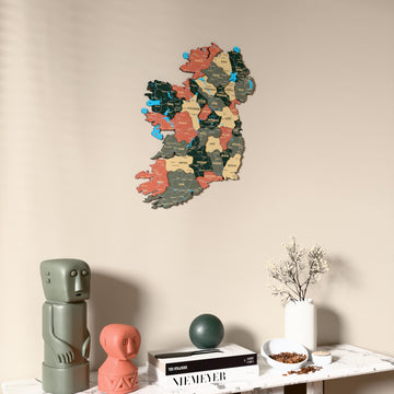 Sage Ireland wooden wall map on a beige wall above a console with figurines