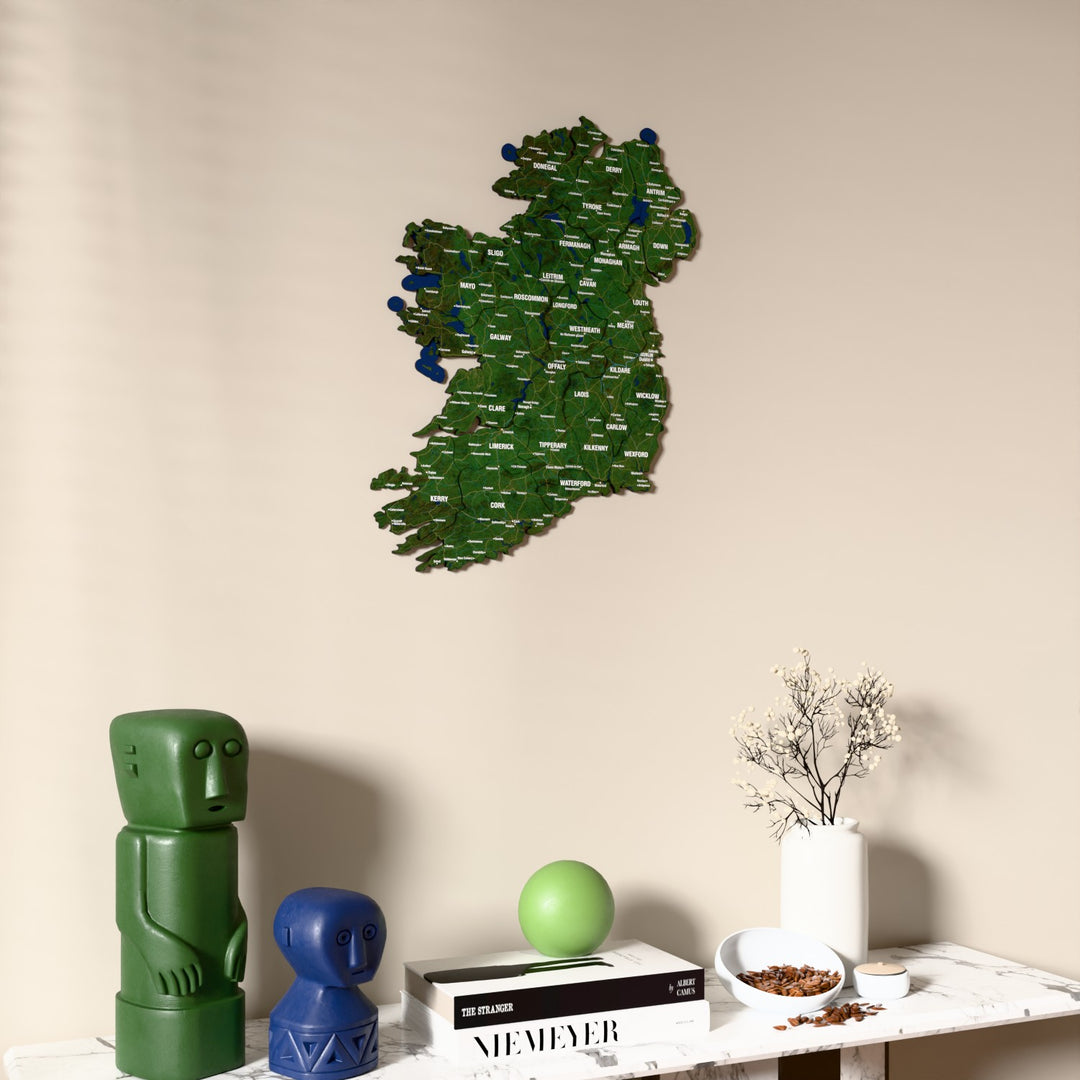 Satellite Ireland wooden wall map on a beige wall above a console with figurines