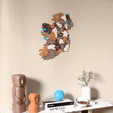 Soil Ireland wooden wall map on a beige wall above a console with figurines