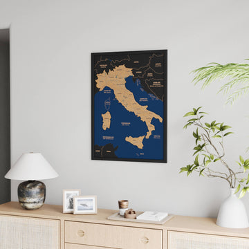 Small black-framed Italy cork map hung beside a plant above a sideboard