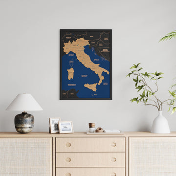 Black-framed Italy cork map hung above a rattan sideboard with a lamp