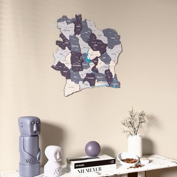 Nimbus Ivory Coast wooden wall map on a beige wall above a console with figurines