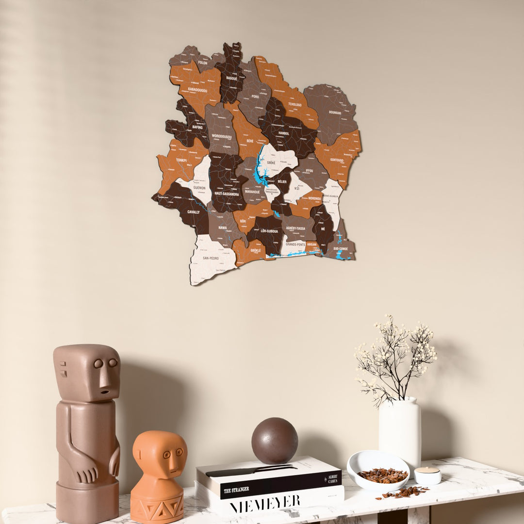 Soil Ivory Coast wooden wall map on a beige wall above a console with figurines
