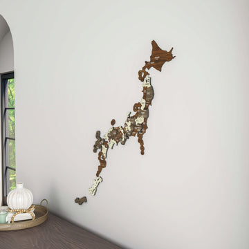 Wooden Japan map hung beside an arched window, with a white vase on a dark wood surface