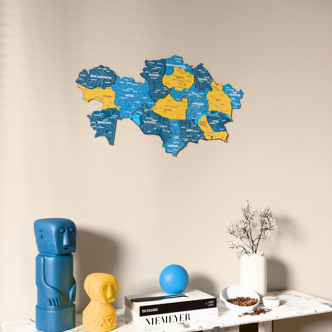 Flag colored Kazakhstan wooden wall map on a beige wall above a console with figurines