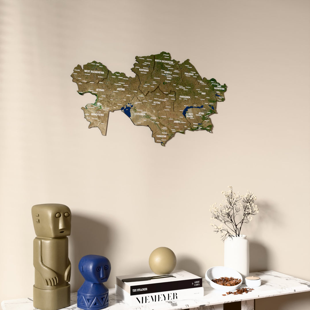Satellite Kazakhstan wooden wall map on a beige wall above a console with figurines