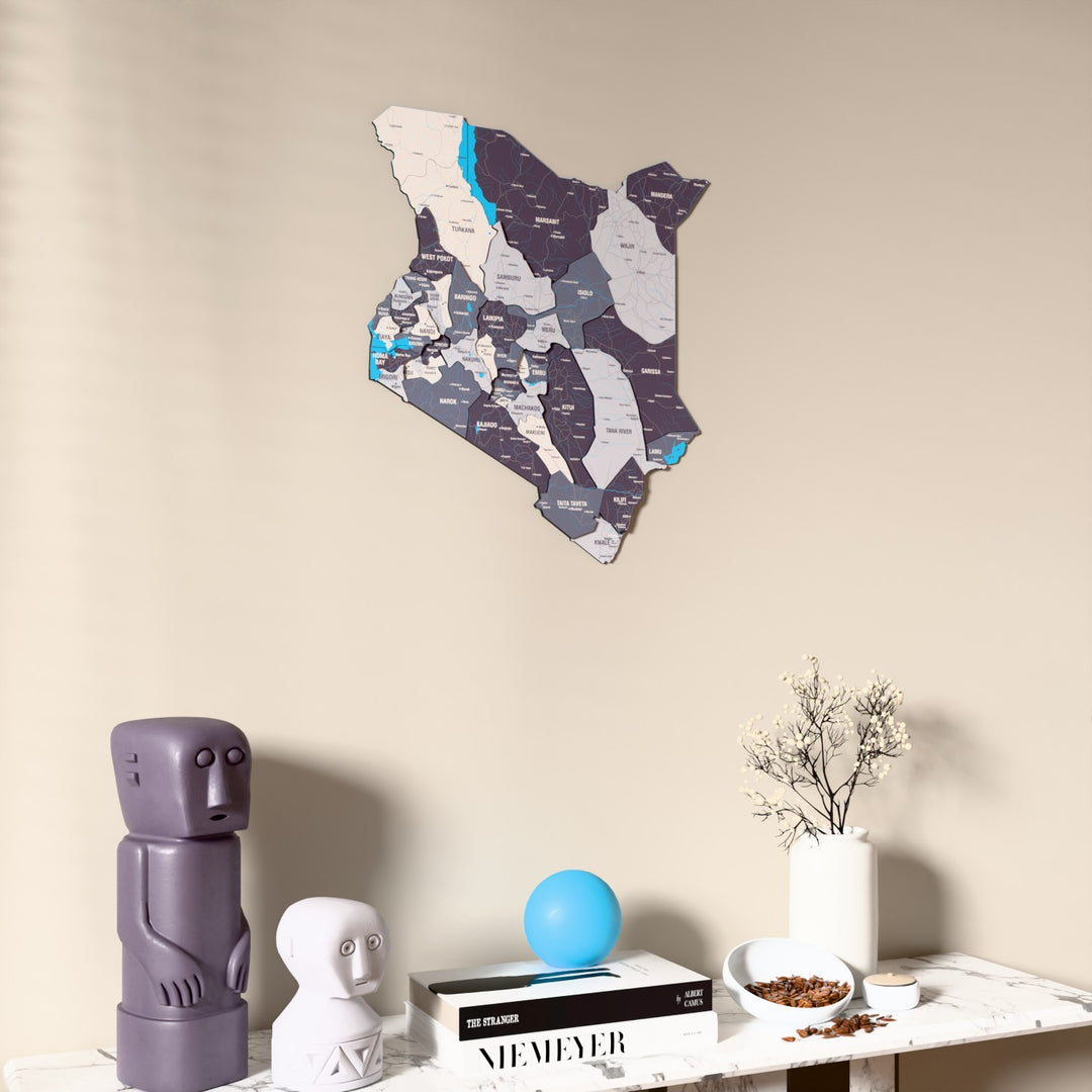 Nimbus Kenya wooden wall map on a beige wall above a console with figurines