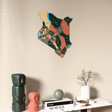 Sage Kenya wooden wall map on a beige wall above a console with figurines