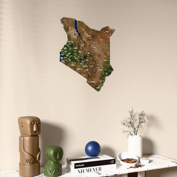 Satellite Kenya wooden wall map on a beige wall above a console with figurines
