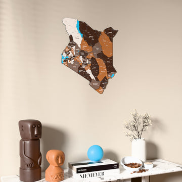 Soil Kenya wooden wall map on a beige wall above a console with figurines