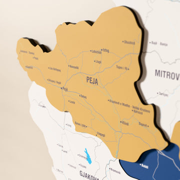 Close-up of the Flag colored Kosovo wooden wall map with layered regions and printed names