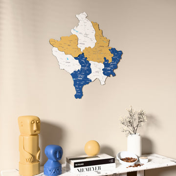 Flag colored Kosovo wooden wall map on a beige wall above a console with figurines