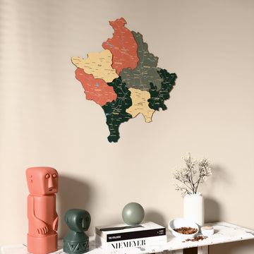 Sage Kosovo wooden wall map on a beige wall above a console with figurines