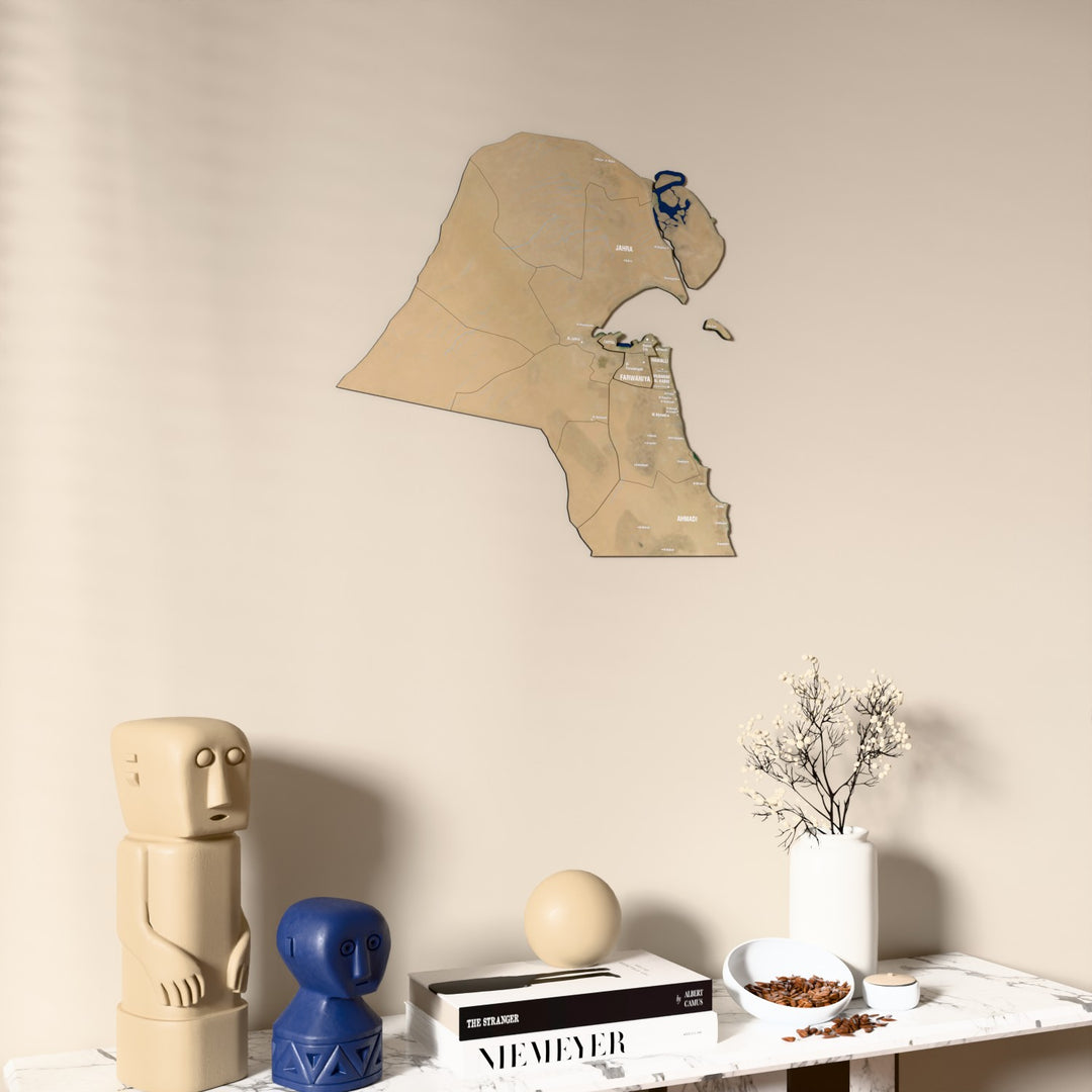 Satellite Kuwait wooden wall map on a beige wall above a console with figurines