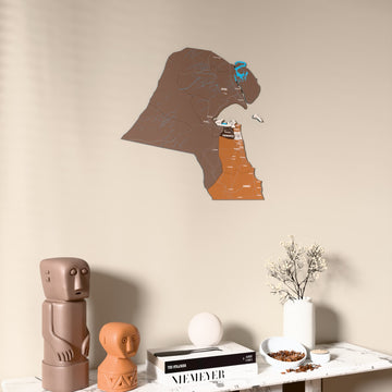 Soil Kuwait wooden wall map on a beige wall above a console with figurines