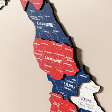 Close-up of the Flag colored Laos wooden wall map with layered regions and printed names