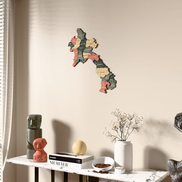 Sage Laos wooden wall map beside a sheer curtain, angled view