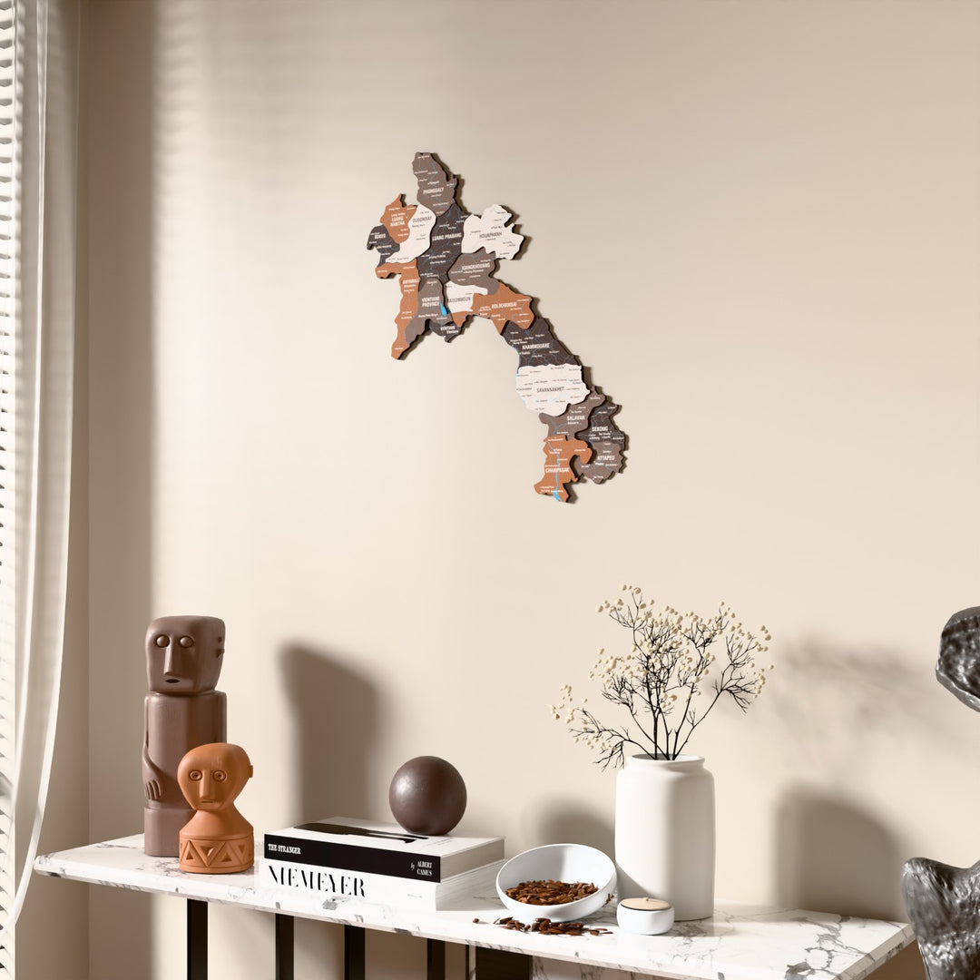 Soil Laos wooden wall map beside a sheer curtain, angled view
