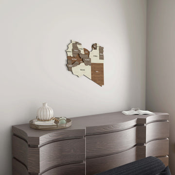 Libya wooden wall map small on a white wall above a wooden dresser with a vase