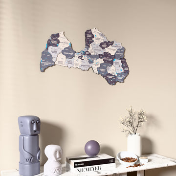Nimbus Latvia wooden wall map on a beige wall above a console with figurines