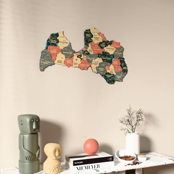 Sage Latvia wooden wall map on a beige wall above a console with figurines