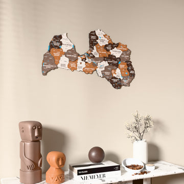 Soil Latvia wooden wall map on a beige wall above a console with figurines