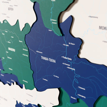 Close-up of the Flag colored Lesotho wooden wall map with layered regions and printed names
