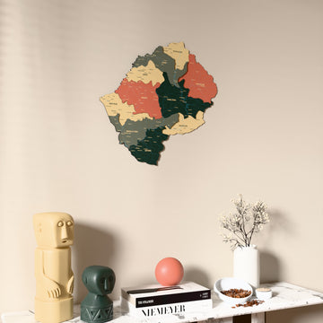 Sage Lesotho wooden wall map on a beige wall above a console with figurines