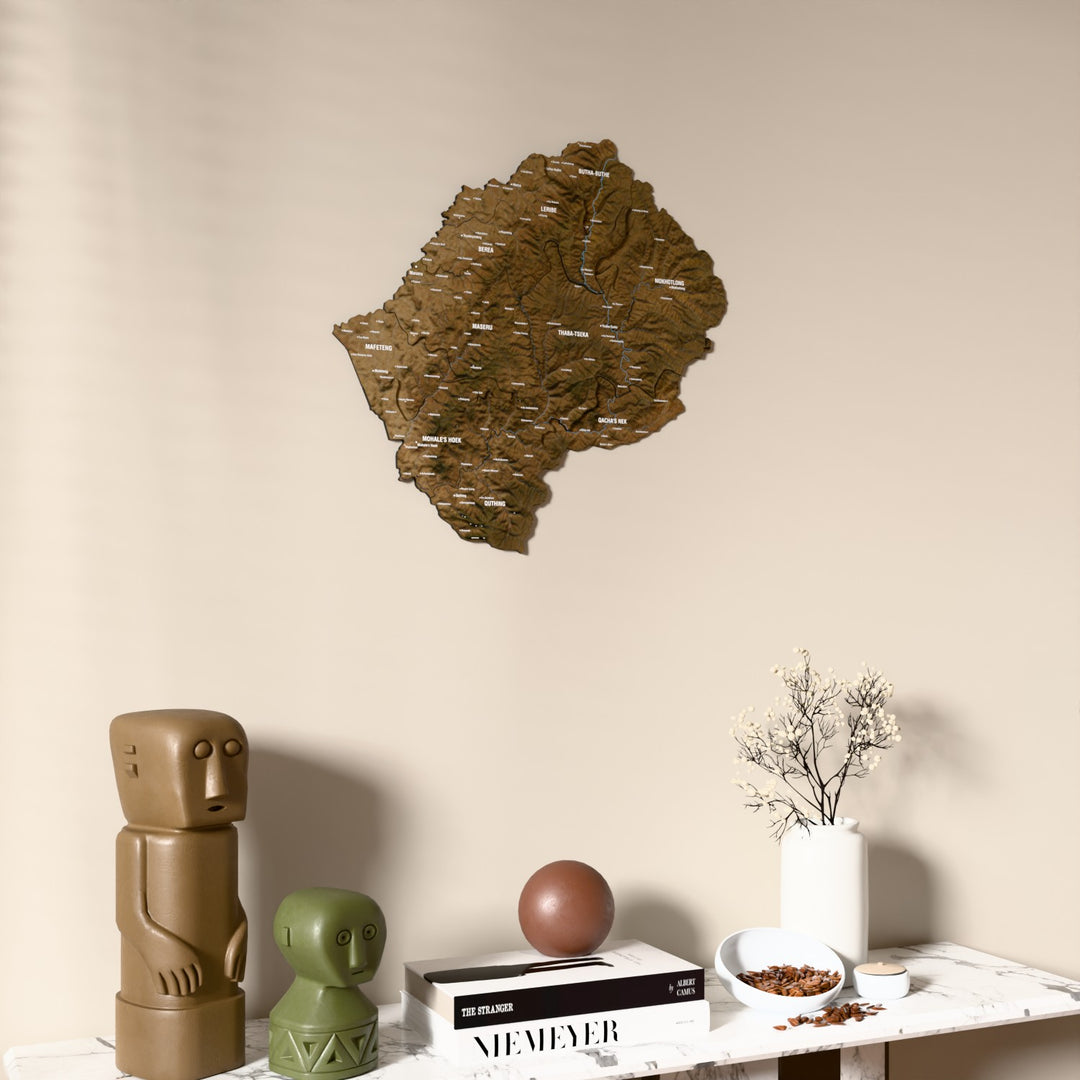 Satellite Lesotho wooden wall map on a beige wall above a console with figurines