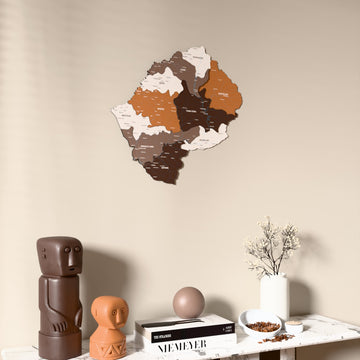Soil Lesotho wooden wall map on a beige wall above a console with figurines