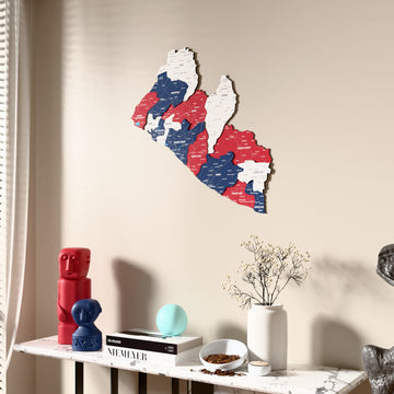 Flag colored Liberia wooden wall map beside a sheer curtain, angled view