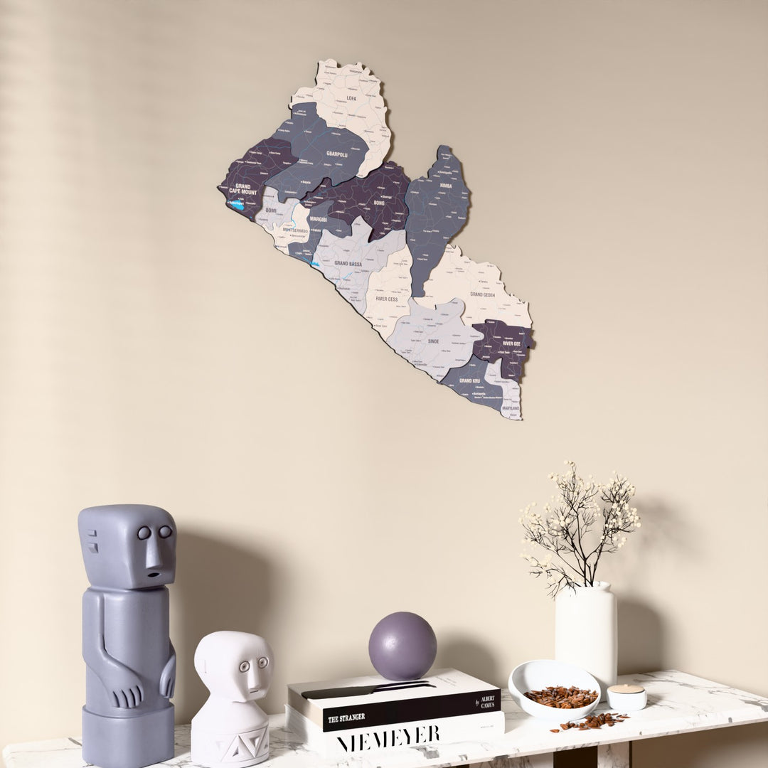 Nimbus Liberia wooden wall map on a beige wall above a console with figurines