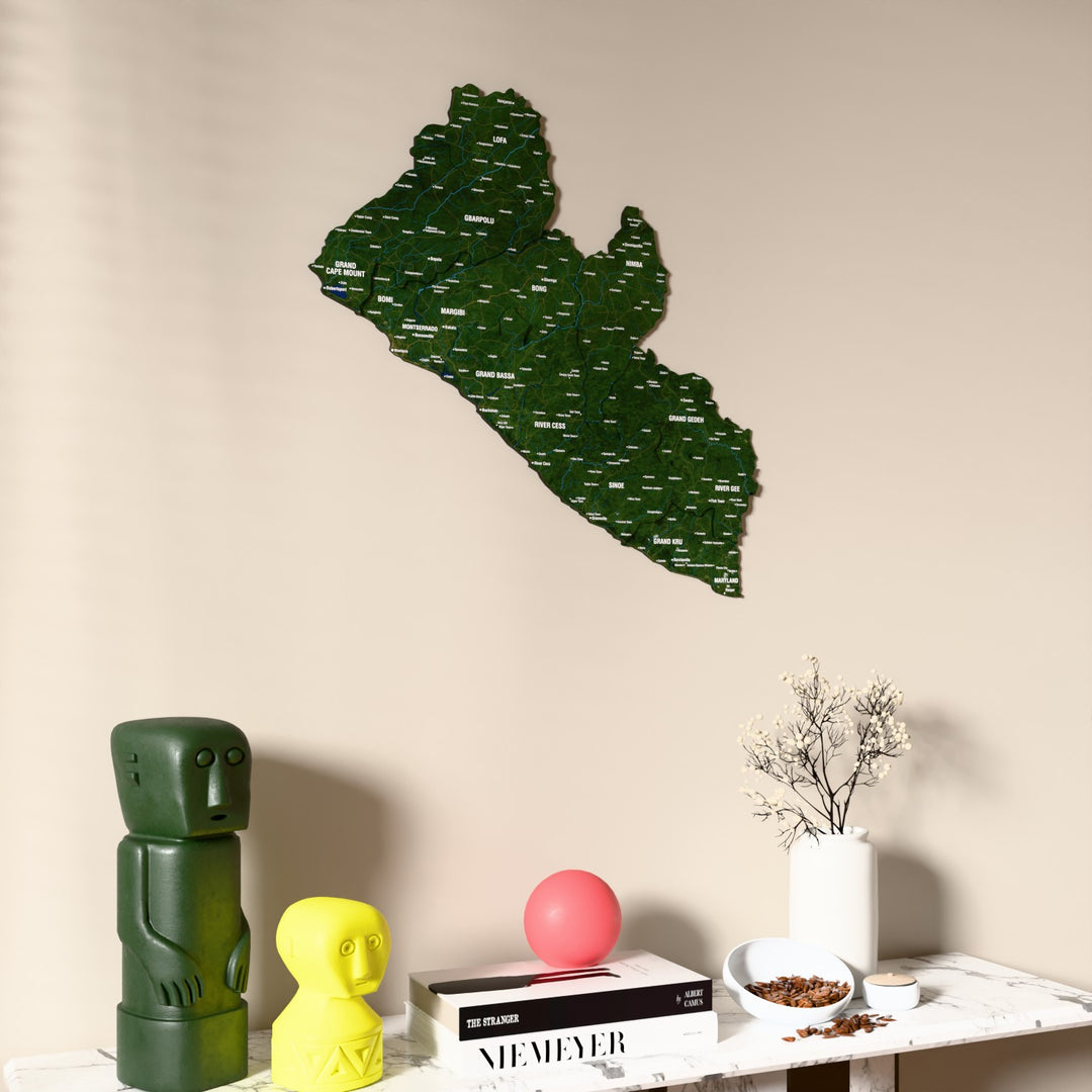 Satellite Liberia wooden wall map on a beige wall above a console with figurines
