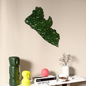 Satellite Liberia wooden wall map on a beige wall above a console with figurines