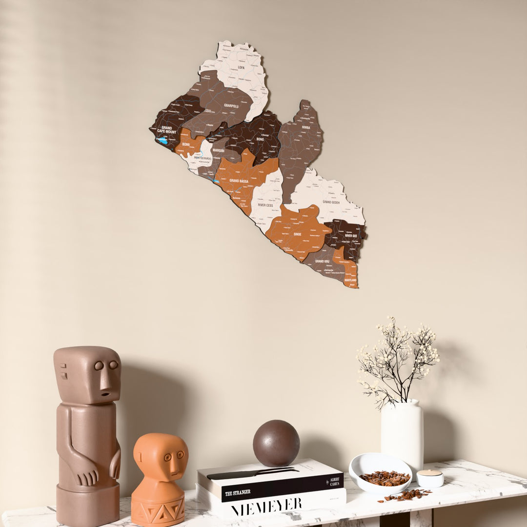 Soil Liberia wooden wall map on a beige wall above a console with figurines