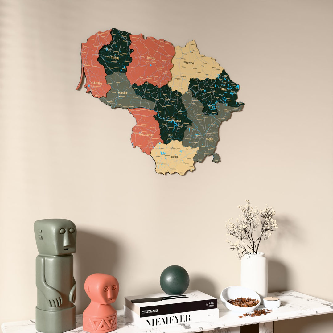 Sage Lithuania wooden wall map on a beige wall above a console with figurines