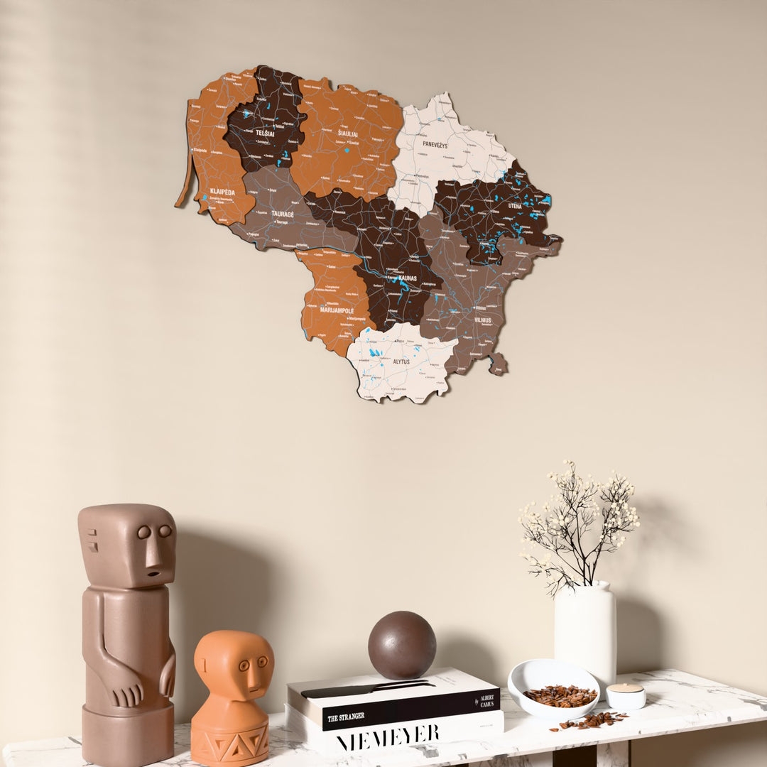 Soil Lithuania wooden wall map on a beige wall above a console with figurines