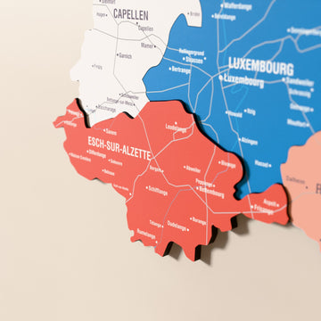 Close-up of the Flag colored Luxembourg wooden wall map with layered regions and printed names