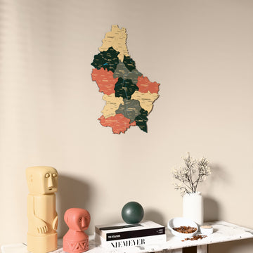 Sage Luxembourg wooden wall map on a beige wall above a console with figurines