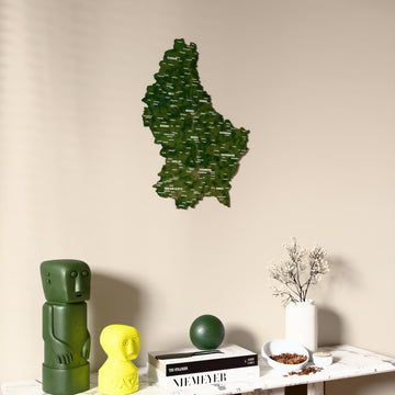 Satellite Luxembourg wooden wall map on a beige wall above a console with figurines