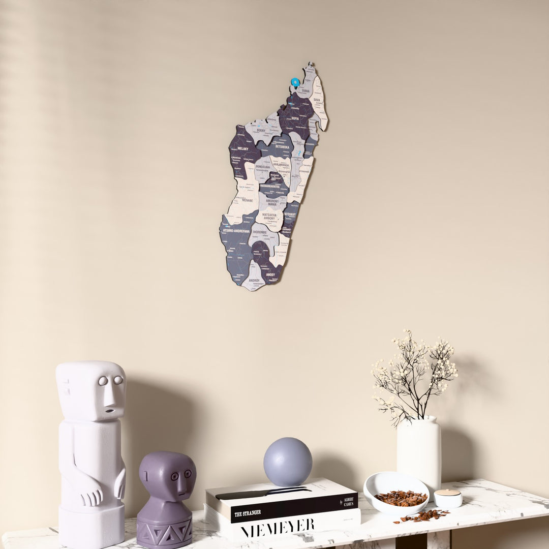 Nimbus Madagascar wooden wall map on a beige wall above a console with figurines