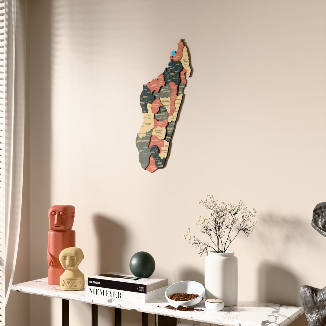 Sage Madagascar wooden wall map beside a sheer curtain, angled view