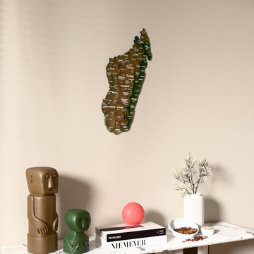 Satellite Madagascar wooden wall map on a beige wall above a console with figurines