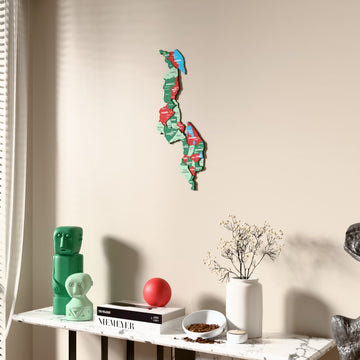 Flag colored Malawi wooden wall map beside a sheer curtain, angled view
