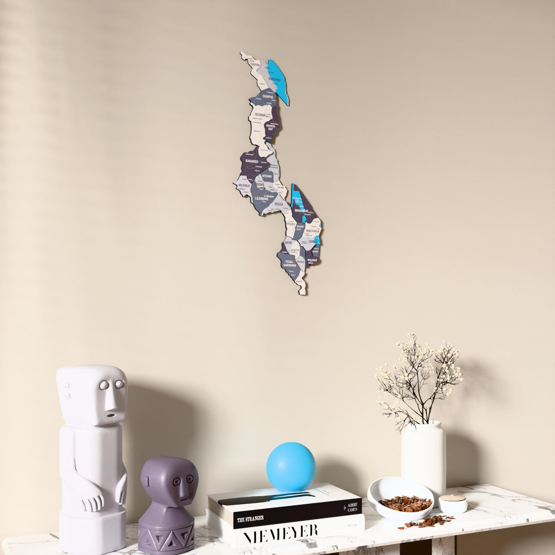 Nimbus Malawi wooden wall map on a beige wall above a console with figurines