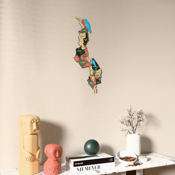 Sage Malawi wooden wall map on a beige wall above a console with figurines
